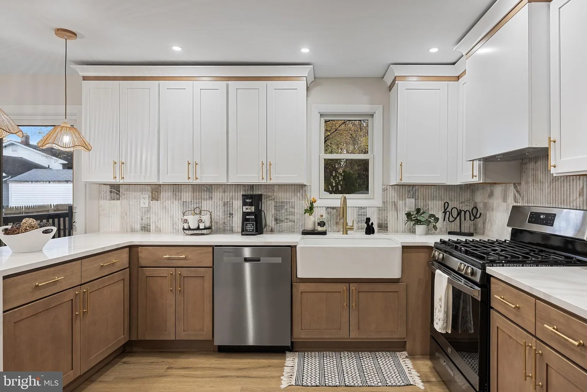 Bright white kitchen with warm wood island and gold pendant lighting