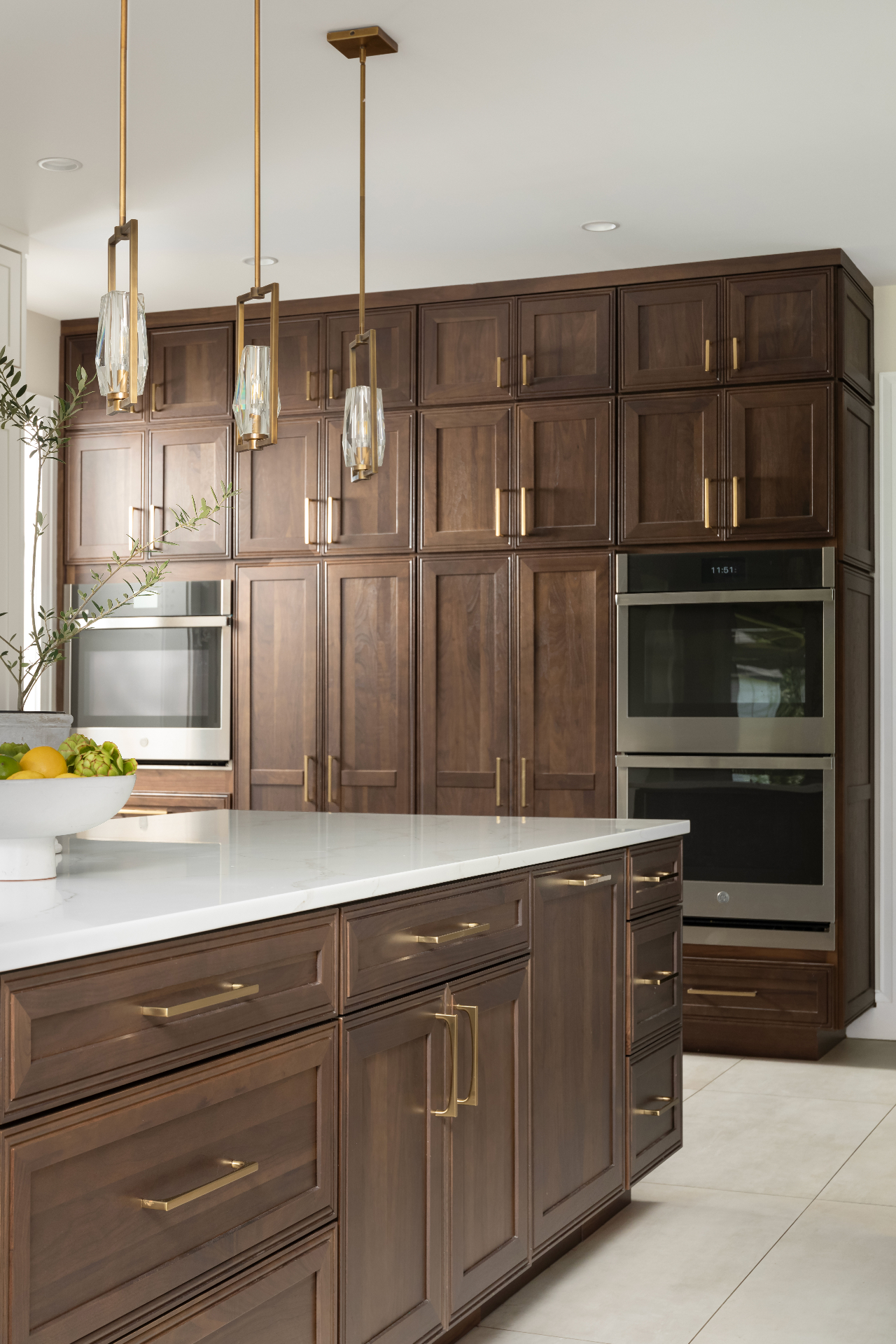 Light oak kitchen with white quartz counters and stainless range